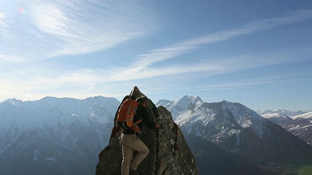 攀爬者奋力爬上岩石的顶峰，冲出大山视频素材