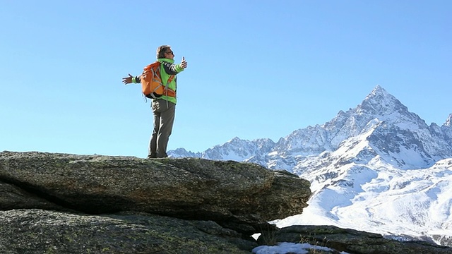 潘在一个徒步旅行者攀登mtn峰顶时，伸出了双臂视频素材
