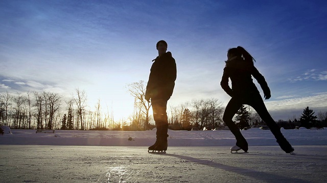 一对年轻的夫妇在冰上一起滑冰。视频素材