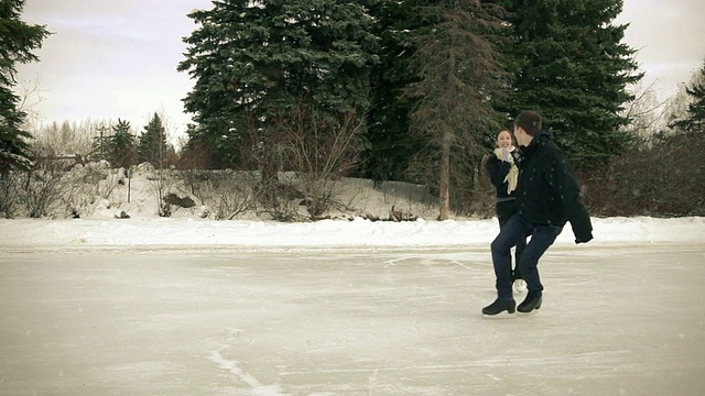 一对年轻的情侣在冬天一起滑冰视频素材