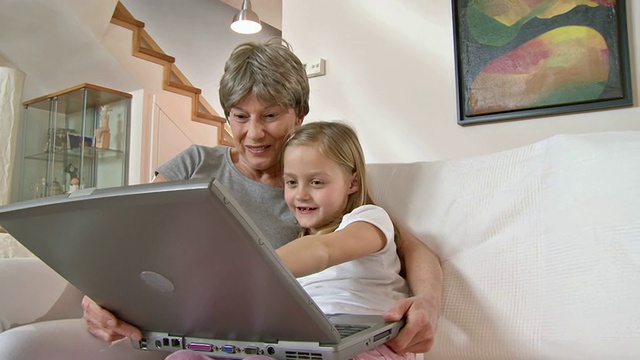 高清:小女孩和奶奶一起用笔记本电脑视频素材