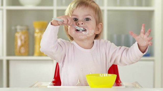 高清:可爱的小女孩用勺子吃东西视频素材