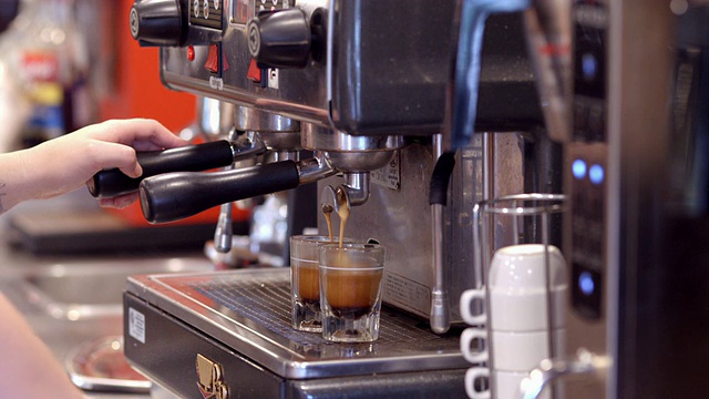 ECU浓缩咖啡机的咖啡在满的时候流入咖啡师的手移开的小酒杯/美国加州的Redlands视频下载