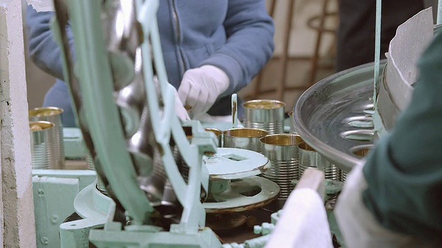 在美国加利福尼亚州安大略省的老式橄榄加工厂，打开的橄榄罐头从传送带上落进填充轮的ECU视频下载