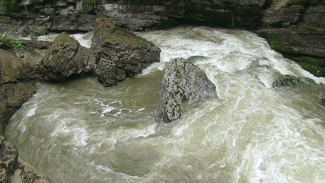 在德国巴伐利亚的阿尔卑斯山/奥伯斯多夫，山间小溪的水在石头之间流动视频素材