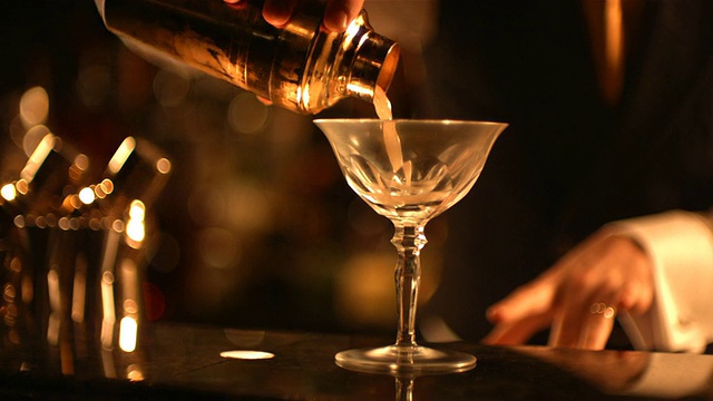 MS SLO MO R/F调酒师服务他的鸡尾酒在玻璃/英国视频素材