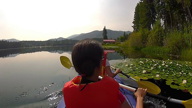 女孩们在湖中划着皮划艇视频素材
