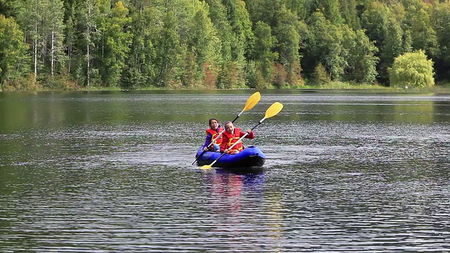 女孩们在湖中划着皮划艇视频素材