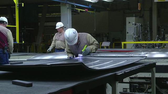 美国印第安纳州普林斯顿，工人们在焊接成小型货车之前检查钣金冲压件视频下载