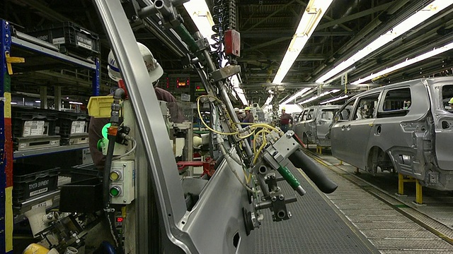 在美国印第安纳州普林斯顿的一家汽车装配厂，女士正在为安装小型货车准备车门视频素材