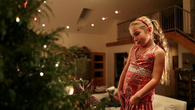 小女孩在圣诞树上挂圣诞装饰品的照片/美国新墨西哥州拉米视频素材