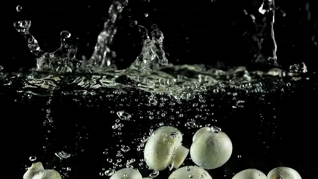 慢镜头:蘑菇溅入水中视频素材