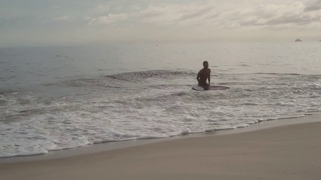 巴西里约热内卢伊帕内玛海滩，一名男孩在冲浪板上冲浪视频素材