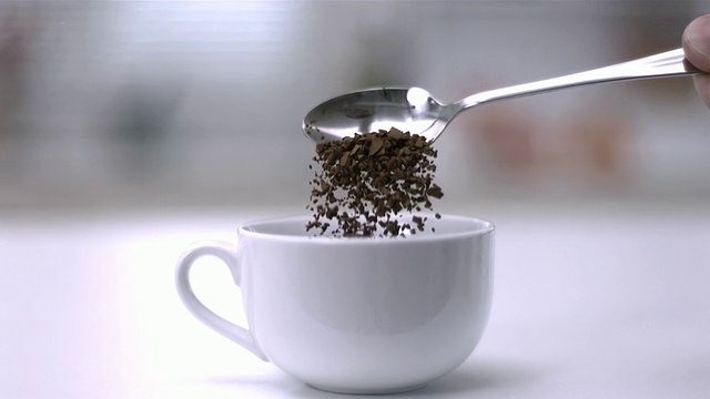 用茶匙把速溶咖啡倒进一个白色的杯子里视频下载