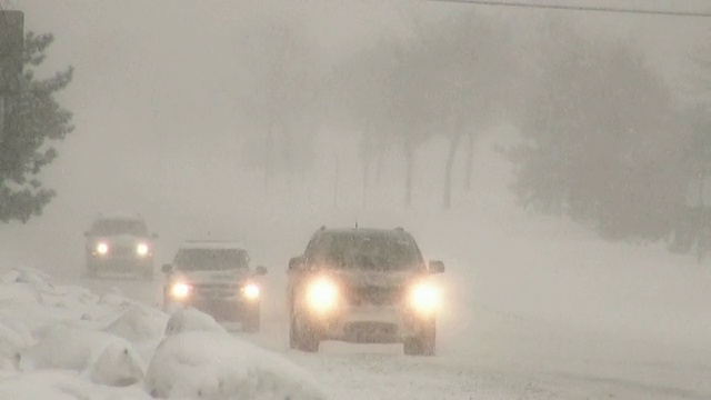 冬天的暴风雪。在湿滑的道路上车辆来往。视频素材