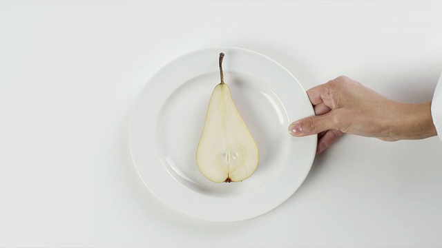 美国内布拉斯加州奥马哈市，一名妇女手持白色盘子，摆上切片的梨视频素材