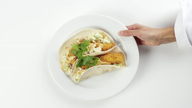 美国内布拉斯加州奥马哈市，一名妇女手持白色盘子，摆着两份鱼肉玉米饼视频下载