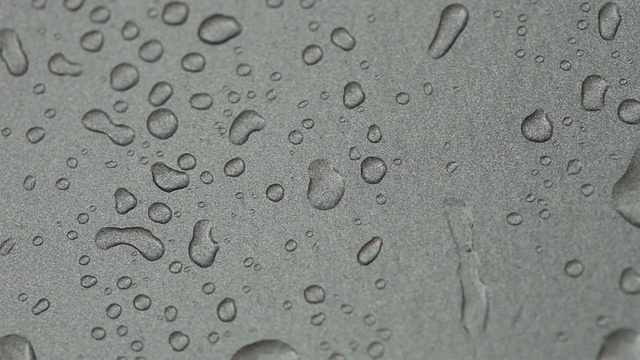 雨滴落在银色金属表面，并向下流动视频素材
