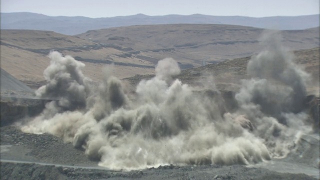 广角静态-爆炸爆发从贫瘠的土地，发送的烟和尘埃云。/南非视频下载