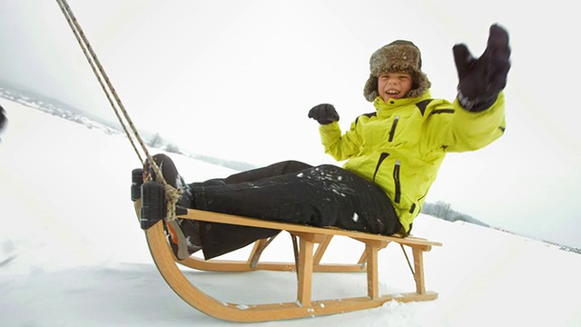 高清慢镜头:拉着快乐的男孩在雪橇上视频下载