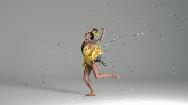 芭蕾舞女演员在银色的五彩纸屑中跳跃的慢镜头视频素材