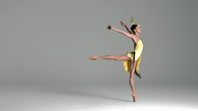 芭蕾舞演员表演的慢动作，穿着黄色的鸟服跳舞视频素材