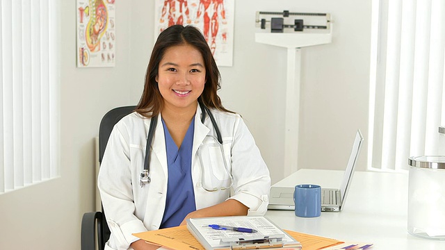亚洲女医生坐在办公桌前的肖像视频下载