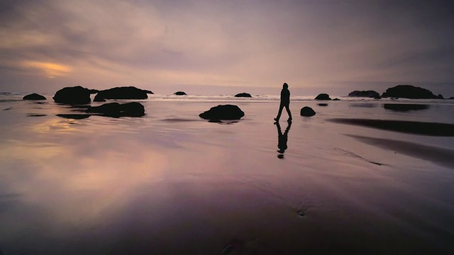 美国俄勒冈州奥福德港，日落时分，一名男子在海滩上行走视频素材