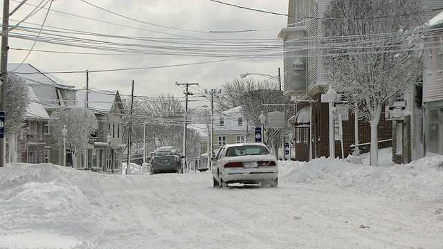 暴风雪过后，汽车行驶在下雪的城市街道上视频素材
