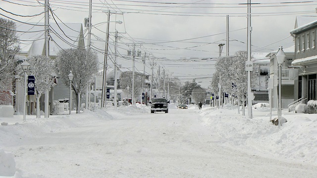 小镇的城市街道上有几辆车在暴风雪后视频素材
