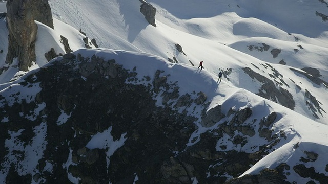登山者行走在白雪覆盖的山顶上视频素材