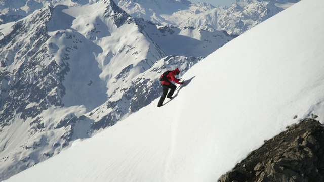 登山者爬上一座白雪覆盖的山视频素材