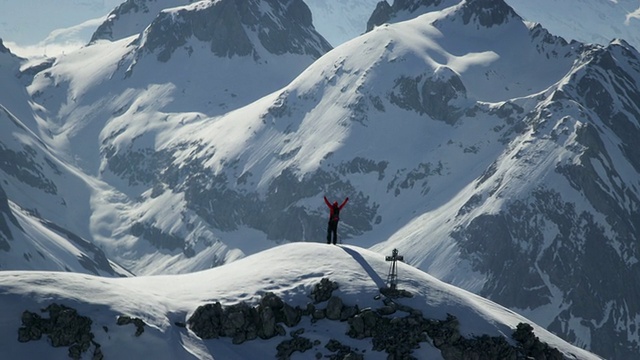 登山者在白雪覆盖的山顶上兴高采烈视频素材