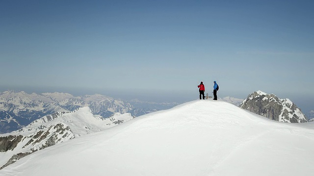 登山者在白雪覆盖的山顶上兴高采烈视频素材