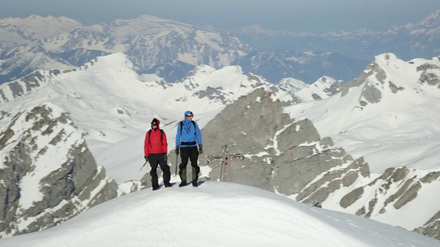 登山者站在白雪覆盖的山峰上视频素材