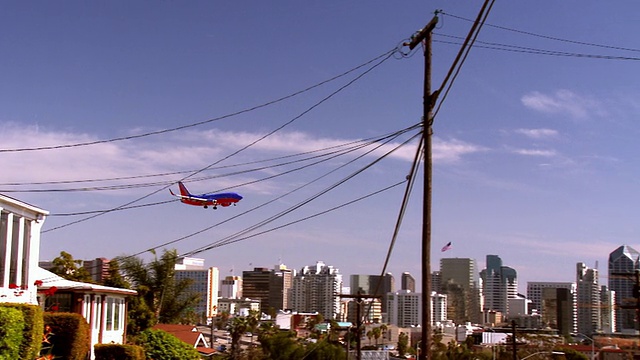 美国加州圣地亚哥，飞机在最后进场低空飞越城市，靠近水面，降落在机场跑道上视频素材