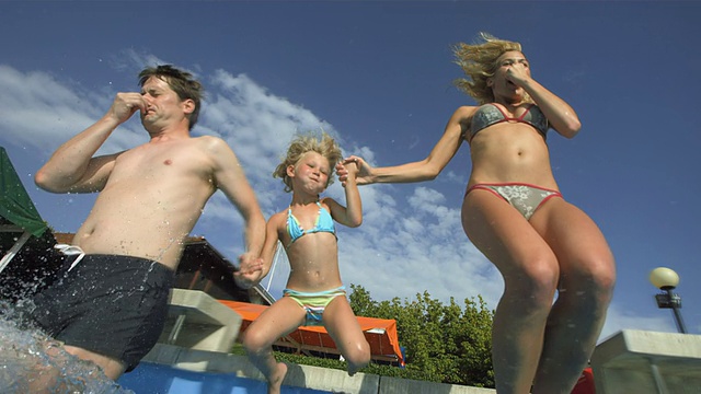HD超级慢动作:年轻的家庭跳进游泳池视频下载