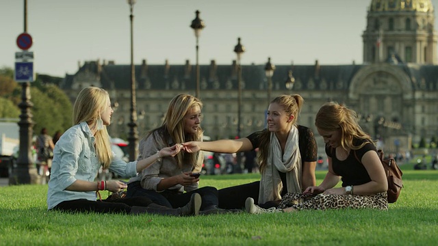 朋友们一起坐在草地上的慢镜头/法国巴黎视频下载