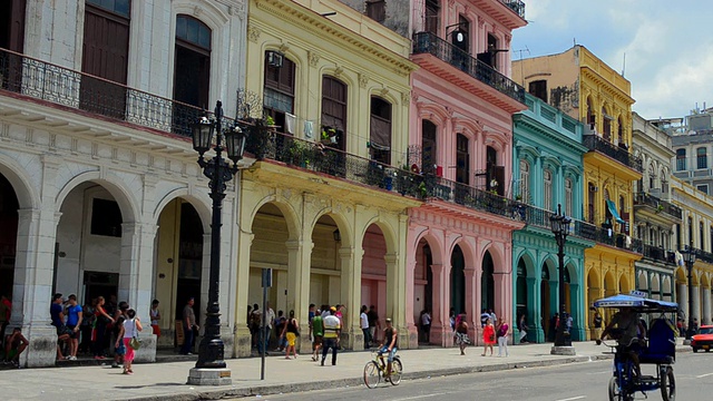 古巴哈瓦那，人们走在首都附近五颜六色的市中心彩色建筑上视频下载