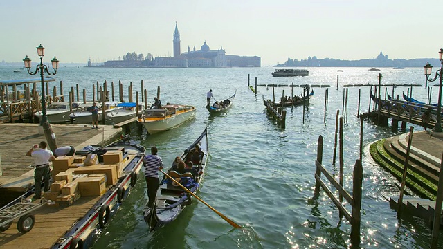意大利威尼斯威尼斯大运河(canal Grande / Venice Veneto)侧运河入口的贡多拉和商业交通视频素材