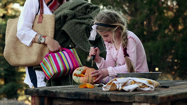 小女孩雕刻南瓜和她的妈妈看/拉米，新墨西哥州，美国视频素材