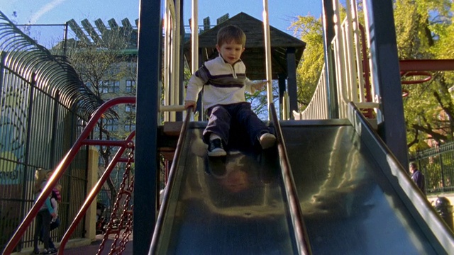 美国纽约公园，男孩从滑梯上滑下来视频素材