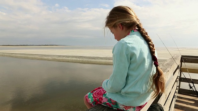 年轻女孩坐在码头/圣西蒙岛，美国乔治亚州视频素材