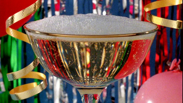 近距离的香槟被倒进香槟酒杯/飘带的背景视频素材