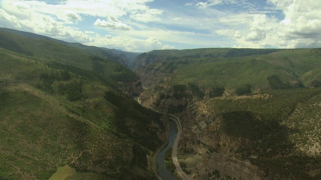 WS ZI鸟瞰图的河流和70号州际公路峡谷和周围的绿色山脉和阳光充满云/格伦伍德峡谷，科罗拉多州，美国视频素材