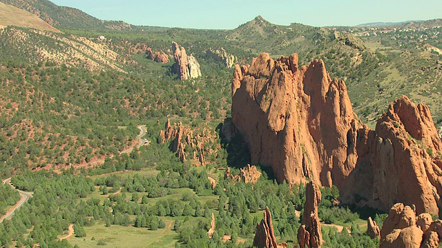 WS DS ZI鸟瞰图的红色岩石形成与周围的山脉覆盖在绿色的阳光/科罗拉多斯普林斯，科罗拉多州，美国视频素材