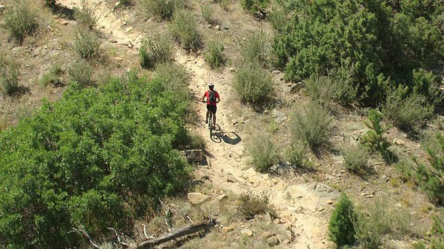 MS DS ZI鸟瞰图骑自行车通过岩石地形与植物和树木在日光下沿着达科他Hogback /丹佛，科罗拉多州，美国视频下载