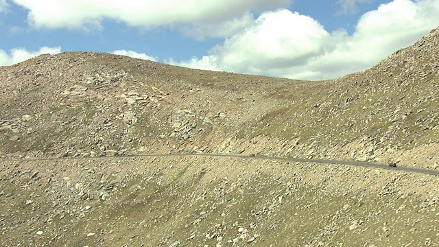 汽车驾驶在蜿蜒的道路上埃文斯山岩石地形的一边/科罗拉多州，美国视频素材