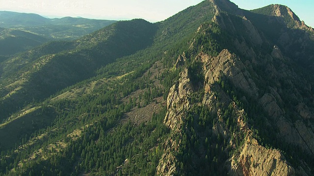 WS DS鸟瞰图在博尔德县的平顶峰与阳光照耀在陡峭的山上与树木/科罗拉多州，美国视频素材
