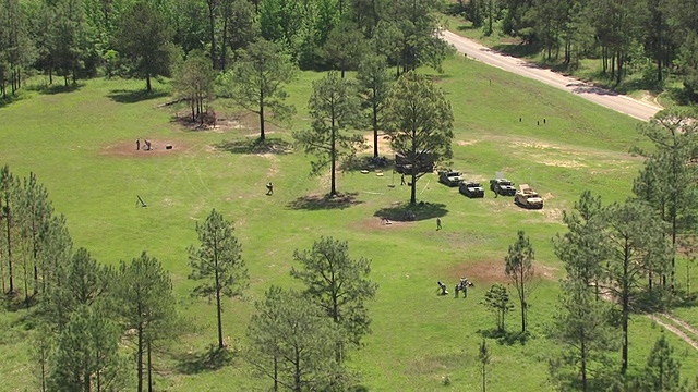 MS航拍开阔的田野和森林与士兵在牧场工作在谢尔比营军事基地/密西西比州，美国视频下载